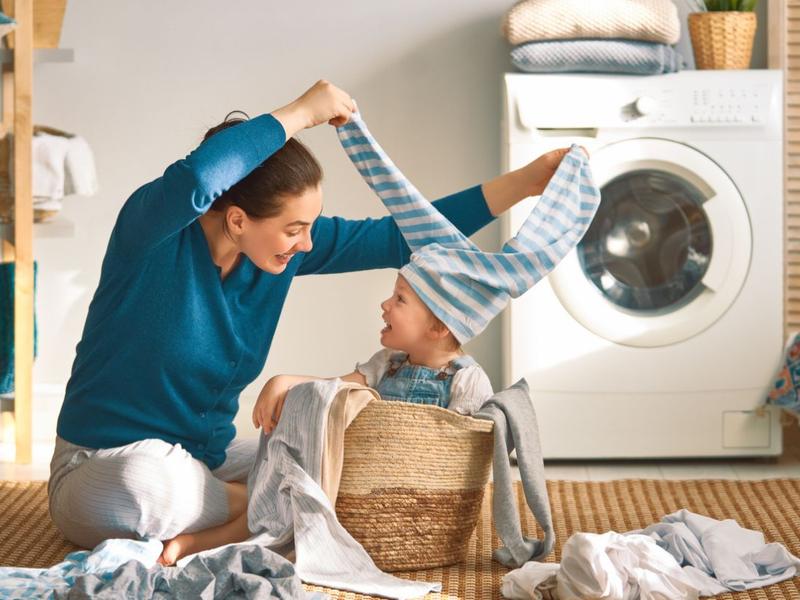 mama e hijo lavando ropa en la lavadora 